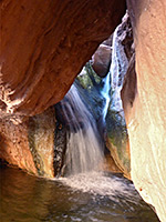 Waterfall beneath a boulder