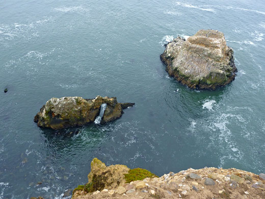 Two small islands, one containing a sea arch