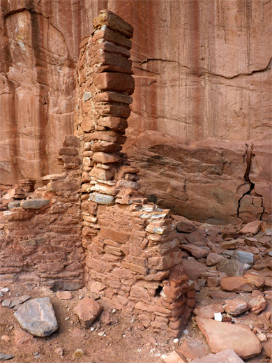 Petroglyphs on the cliff behind a broken wall