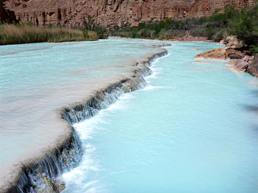 Long travertine dam, parallel to the river banks