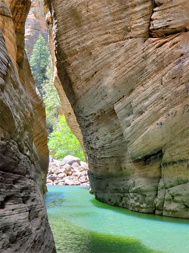 Sandstone cliffs and a long, deep, green pool