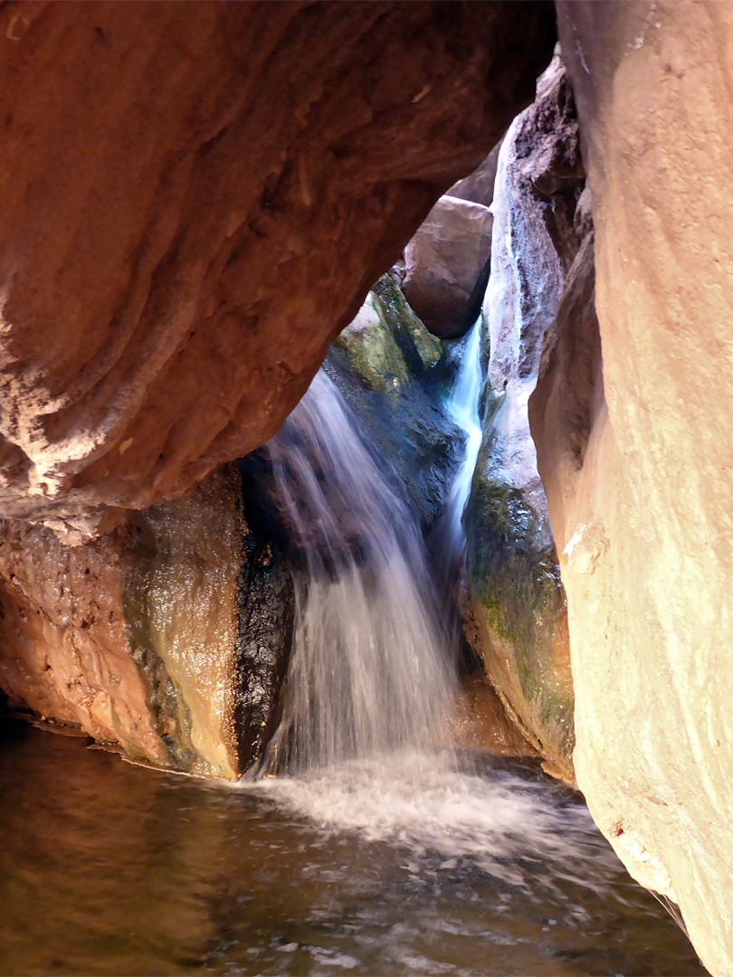 Waterfall beneath a boulder