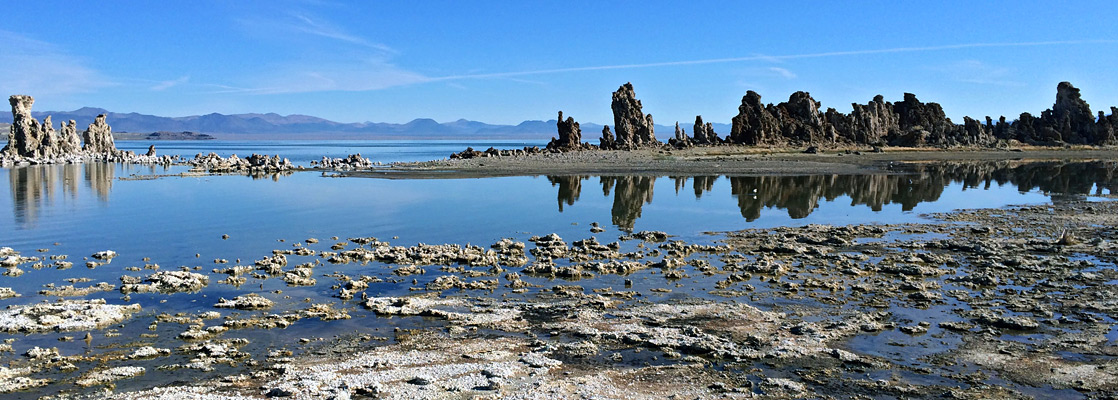 Reflections of tufa spires on a shallow part of the lake