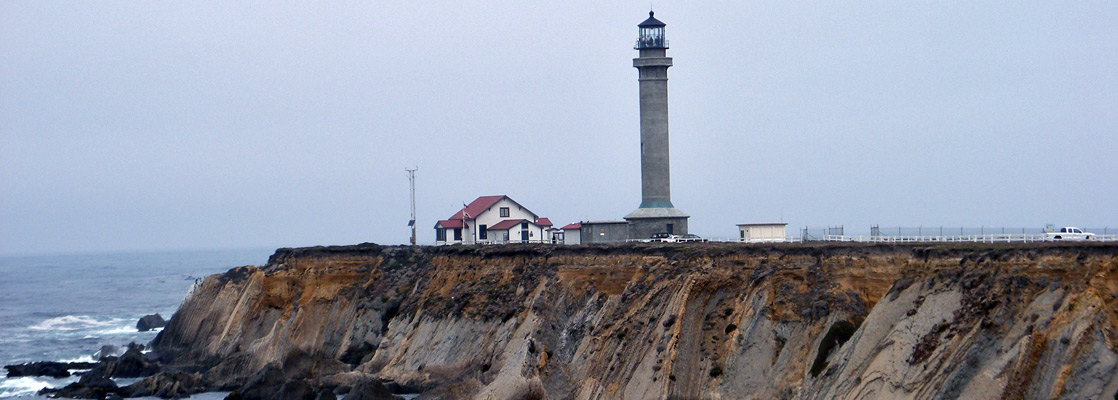 Cliffs formed of steeply-angled sandstone, beneath Point Arena Lighthouse