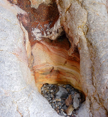 Pebbles in a yellow-red pothole