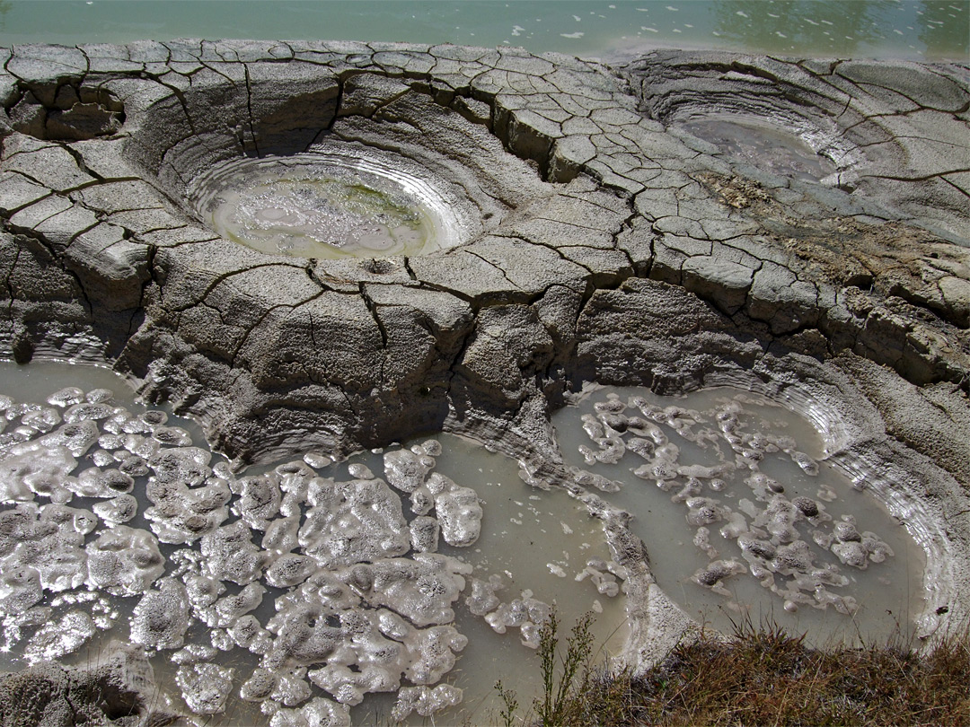 Mud pots at the edge of the lake
