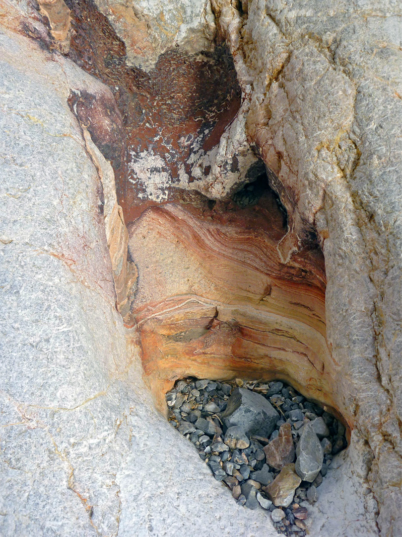 Pebbles in a yellow-red pothole