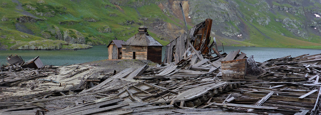 Flattened buildings beside two surviving cabins