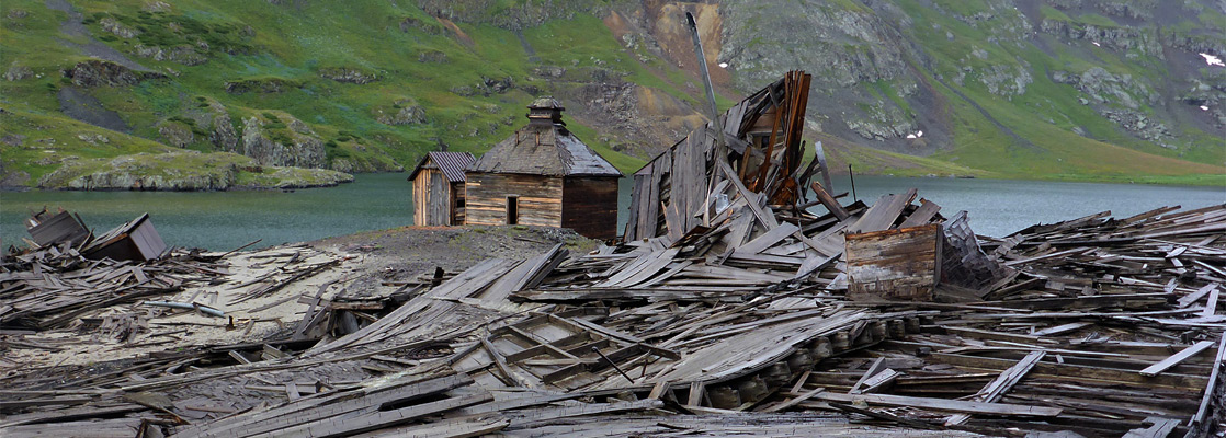 Flattened buildings beside two surviving cabins