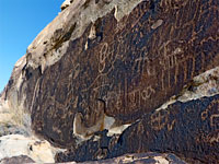 Petroglyphs on a dark cliff