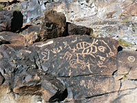 Petroglyphs on a dark boulder