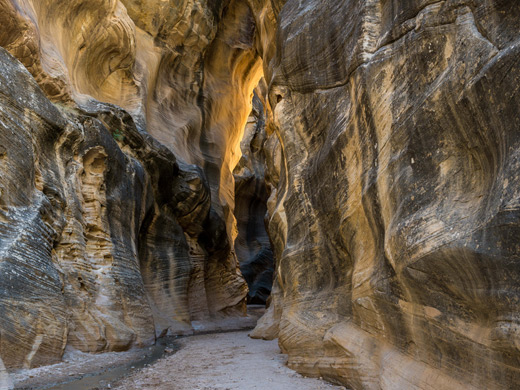 Narrow passage between greyish-yellow sandstone walls