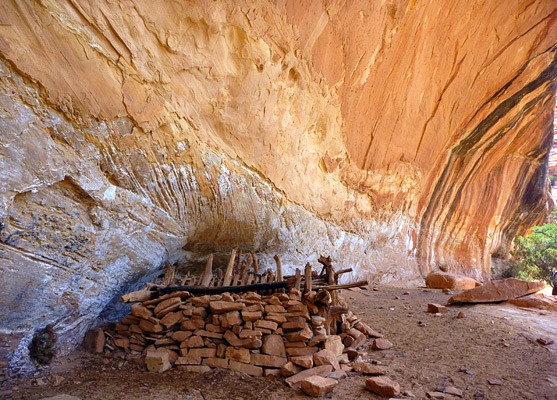 Log and stone kiva, in a streaked sandstone alcove