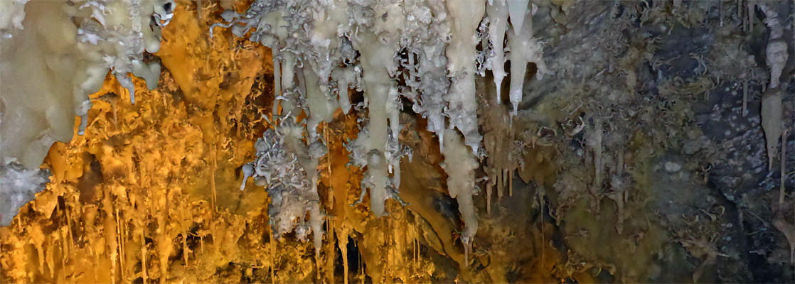 Orange illumination on white formations, Timpanogos Cave