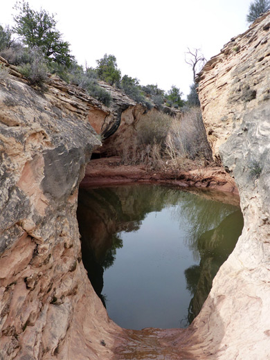 Overhanging cliffs either side of a deep pool
