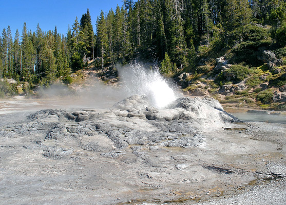 Minute Man Geyser erupting, next to the trail through the geyser basin